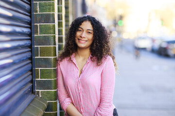 Fototapeta premium portrait of a young woman in the street looking happy