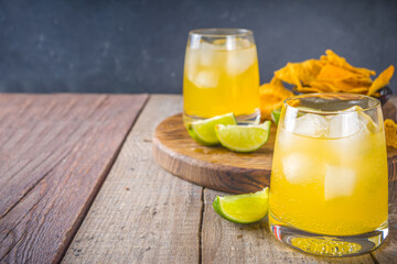 Summer boozy citrus cocktail, citrus margarita, tequila drink with salt and Mexican chips, Summer...