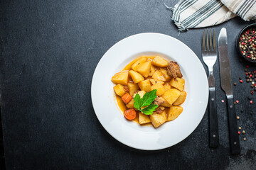 goulash with potatoes and meat stewed vegetables and pork ready to eat on the table for healthy...
