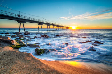 Pont del petroli Bridge that goes into the sea at sunrise, Badalona, Spain