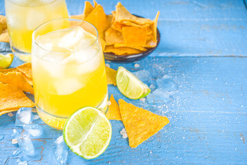 Summer boozy citrus cocktail, citrus margarita, tequila drink with salt and Mexican chips, Summer cold cocktail concept, copy space