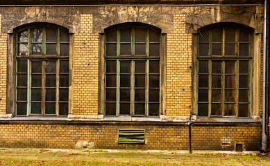 three large old windows in an old disused building. old building with windows