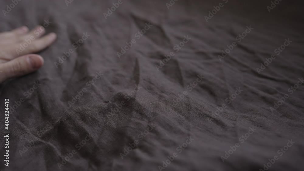 Wall mural Slow motion handheld shot of man touch brown linen cover