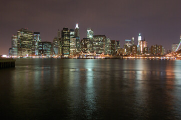 Naklejka na ściany i meble Vista panoramica nocturna del skyline de Manhattan (Nueva York). Rio Hudson. Puente de Brooklyn. Estados Unidos de America