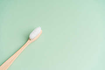 Eco friendly dental health antibacterial bamboo wood toothbrush on green background