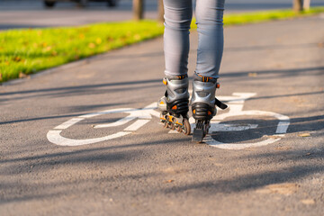 Active leisure. A sportive girl is rollerblading in an autumn park