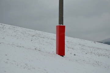 foam barrier on a pole near the ski slope. The protective mattress covers the poles at the lift and...