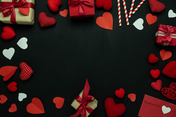 Table top view image of decoration valentine's day background concept.Flat lay arrangement of red shape gift box with essential items on modern rustic black wood with middle space for mock up design