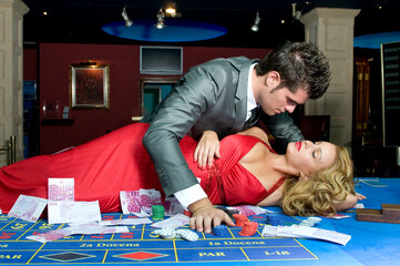 young couple in love in the casino on the gaming table
