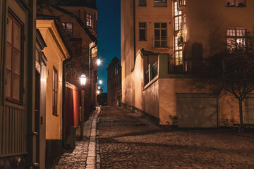Fototapeta na wymiar Evening street in Stockholm. Night cityscape in warm colors.
