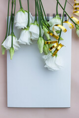 white bouquet of roses on a light background,with open blank notepad,space for text