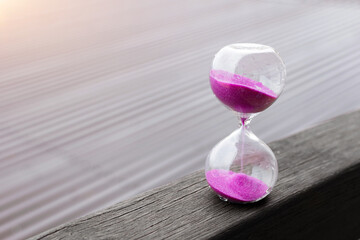 Hourglass with pink sand. Deadline, transience of time concept.