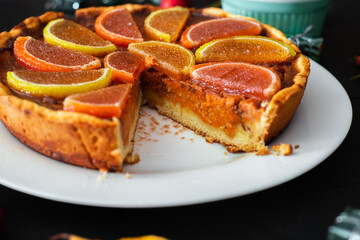 Piece of pumpkin pie on a black background. Vegetarian baked goods, dessert.