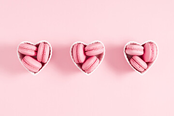 Creative minimal Valentine's Day concept with macaroons. Pink macaroons, valentines on pastel pink background. Flat lay, top view, copy space
