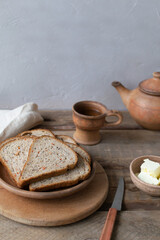 Homemade carrot bread with bran and tea in ceramic dishes. Healthy nutrition concept. Rustic style. Copy space. Vertical orientation.