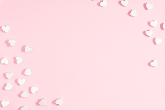 Valentine's Day concept. valentines, white hearts confetti on pink background. Flat lay, top view, copy space