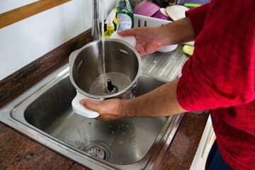 man's hands scrubbing kitchen robot parts
