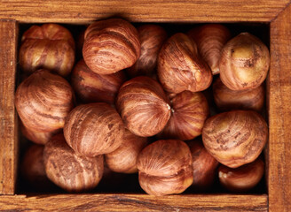 Hazelnuts in wooden box on brown wood background. Healthy food. Vegetarian nutrition