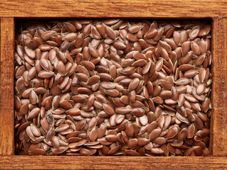 Flax seeds in wooden box on brown wood background. Healthy food. Vegetarian nutrition
