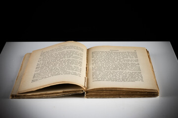 old yellowed book vintage open on a white table on a black background