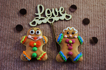 Fototapeta na wymiar Two gingerbread men boy and girl hold the inscription love. Valentine's Day