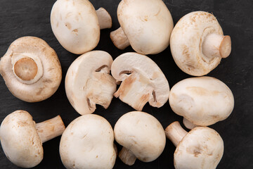Champignon mushrooms  cut in half placed on black slate