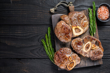 Osso buco cooked Veal shank steak,  italian ossobuco. Black wooden background. Top view. Copy space
