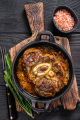 Stew veal shank meat OssoBuco,  italian osso buco steak. Black wooden background. Top view