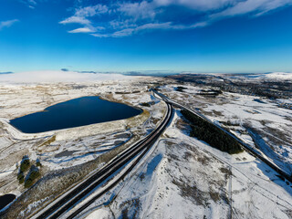 Aerial view of a major road running through a snowy landscape