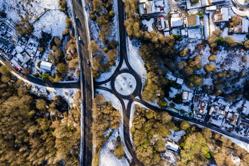 Aerial view of a small traffic roundabout and streets in a snow covered town