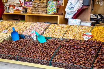 Different nuts are on the counter at the seller in the market