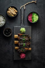 Braise beef short ribs, asian style with rice and radish, dark photo, flat lay