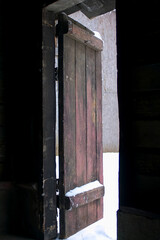 half-open door from the room to the winter street