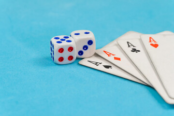 Four aces and two dice on a blue background with copy space