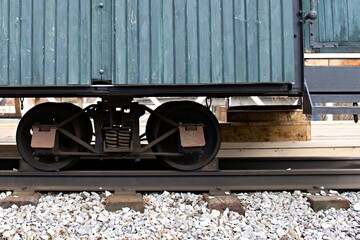 old railroad train wagon on cart with metal wheels