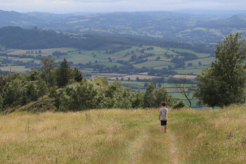 Fototapeta na wymiar Boy walking across the hills in the countryside