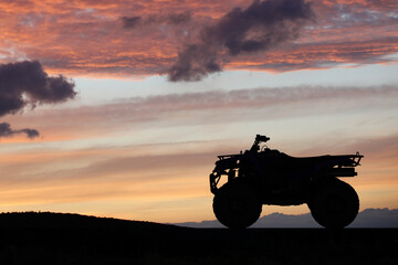Silhouette ATV or Quad bike in the sunset. Holiday exploration concept