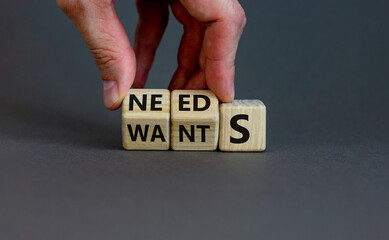 Wants or needs symbol. Hand turns cubes and changes the word 'wants' to 'needs'. Beautiful grey background, copy space. Valentines day and wants or needs concept. - obrazy, fototapety, plakaty