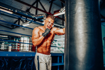 Fototapeta na wymiar Boxer training on a punching bag in the gym.