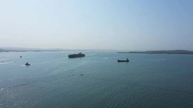 Cargo ship enters to the port aerial view.