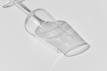 Champagne glass on white surface. Glass with shadow on white table.