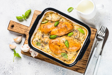 Baked chicken breast with mushrooms in cream sauce. Top view on white kitchen table.