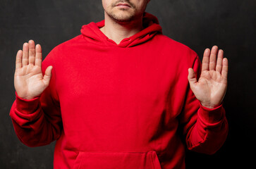 White guy in red sweatshirt show free hands gesture on dark background