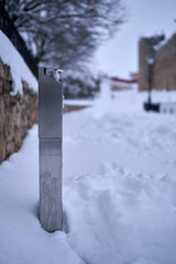 Hydro-alcoholic hand sanitizer gel dispenser in the middle of the snow after Filomena Snowstorm in Spain. COVID, GEL, DISPENSER