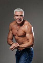 Fototapeta na wymiar Bodybuilder shows his muscule in studio on black background