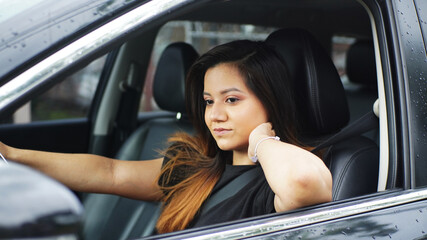 Fototapeta na wymiar Beautiful young girl driving car and smiling
