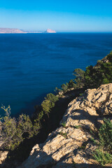 Fototapeta na wymiar View over the ocean to the rock 'Ifach' of Calpe with steep cliffs from natural park 'Serra Gelada' in Albir, Spain