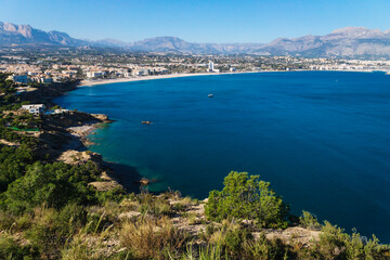 Fototapeta na wymiar Panoramic view to the ocean bay of Albir with mountains in the background seen from natural park 'Serra Gelada' in Albir, Spain