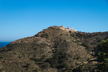 Fototapeta na wymiar Lighthouse on top of mountain in natural park 'Serry Gelada' in Albir, Spain