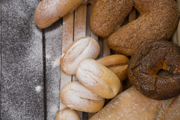Bakery - gold rustic crusty loaves of bread and buns on black chalkboard background top view